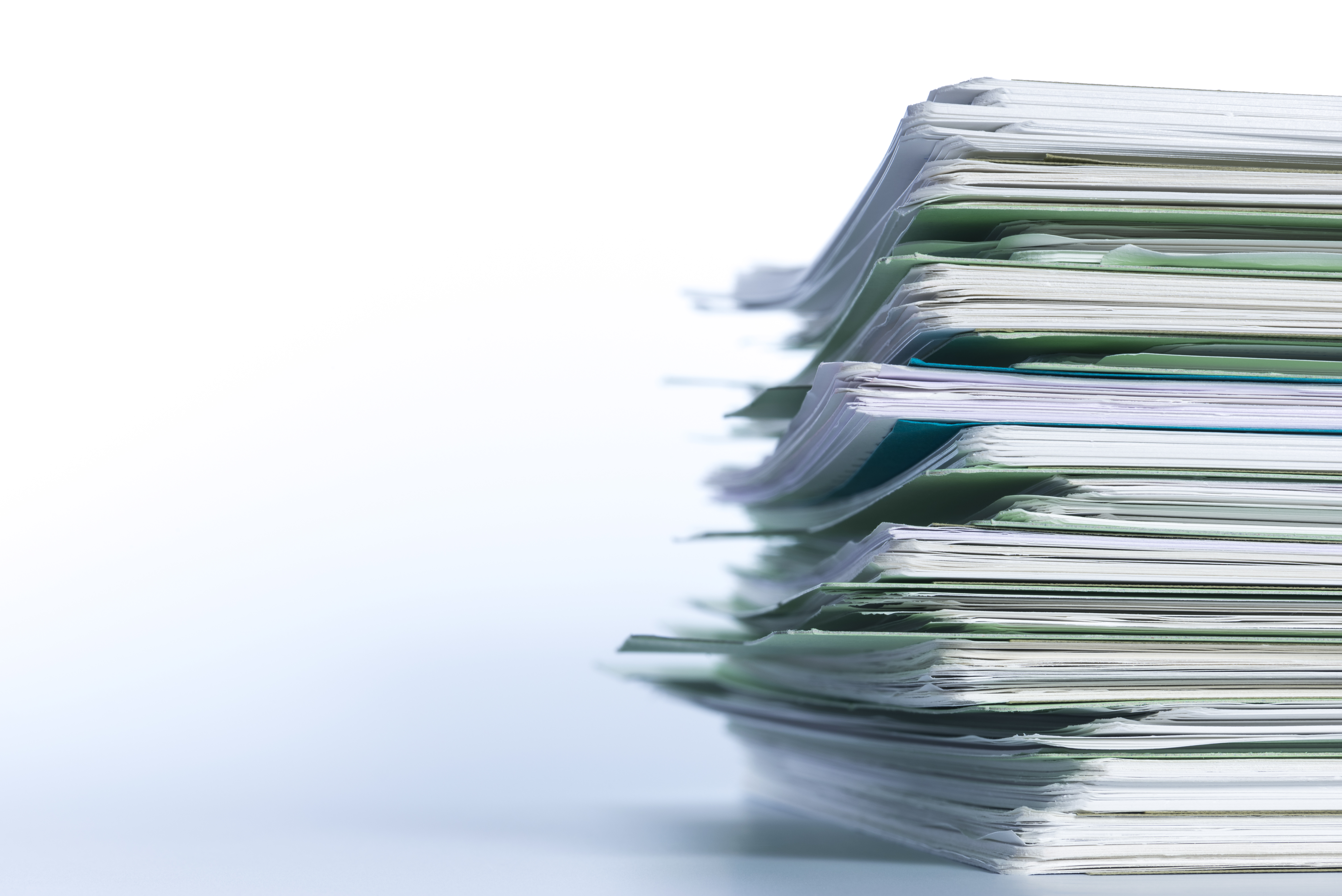 A stack of papers piled high, positioned where it is slightly cut off on the right hand side