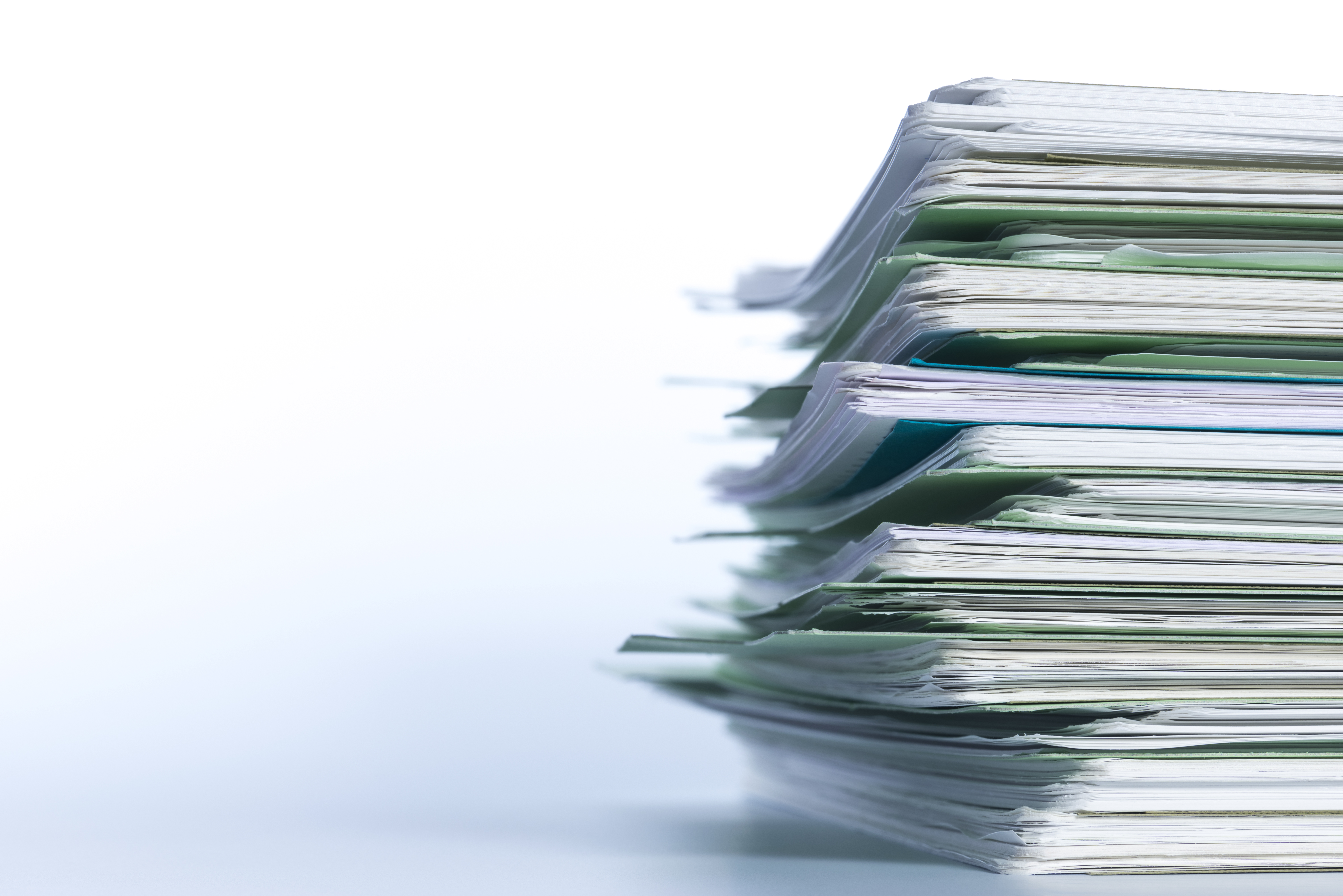 A stack of papers piled high, positioned where it is slightly cut off on the right hand side